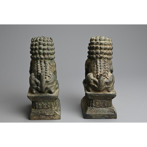 266 - A PAIR OF BRONZE MODELS OF GUARDIAN LIONS, 20TH CENTURY. The male and female lions seated on a raise... 