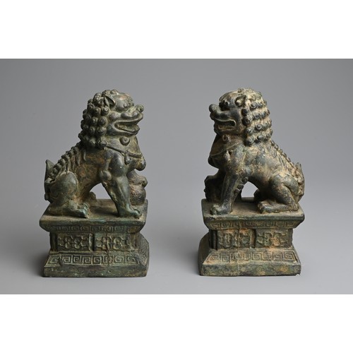 266 - A PAIR OF BRONZE MODELS OF GUARDIAN LIONS, 20TH CENTURY. The male and female lions seated on a raise... 