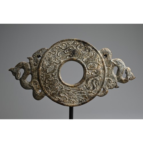 268 - A LARGE CHINESE HARDSTONE BI DISC. Archaic style carved in relief with dragons, flanked by a pair of... 