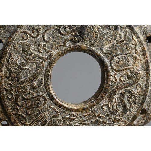 268 - A LARGE CHINESE HARDSTONE BI DISC. Archaic style carved in relief with dragons, flanked by a pair of... 