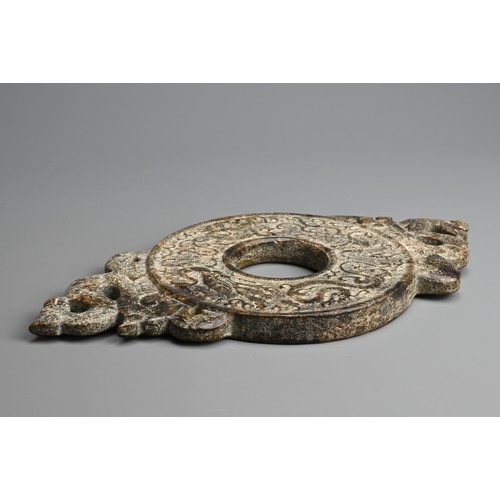 268 - A LARGE CHINESE HARDSTONE BI DISC. Archaic style carved in relief with dragons, flanked by a pair of... 