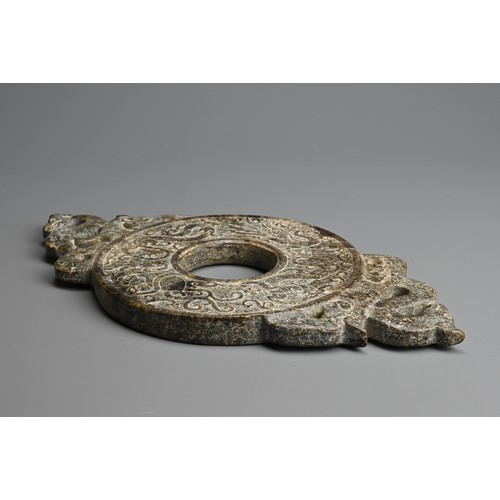 268 - A LARGE CHINESE HARDSTONE BI DISC. Archaic style carved in relief with dragons, flanked by a pair of... 