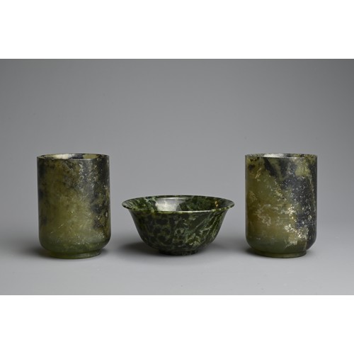 270 - THREE CHINESE SPINACH JADE CUPS AND BOWL, 20TH CENTURY. Dark green and black mottled jade carved int... 