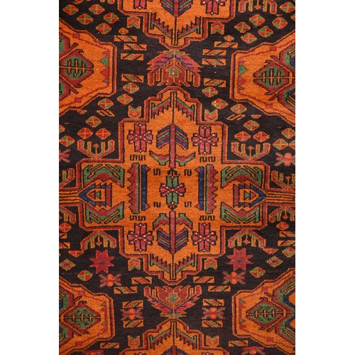 337 - AN AFGHAN CAMEL WOOL RUG, 20TH CENTURY. With geometric roundels enclosing foliate motifs predominate... 