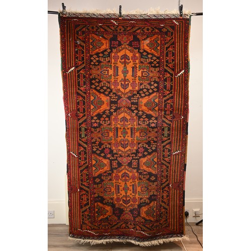 337 - AN AFGHAN CAMEL WOOL RUG, 20TH CENTURY. With geometric roundels enclosing foliate motifs predominate... 