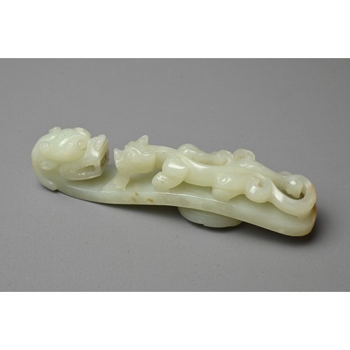 377 - A LARGE CHINESE PALE CELADON JADE BELT HOOK, QING DYNASTY, 18/19TH CENTURY. Carved in openwork on to... 