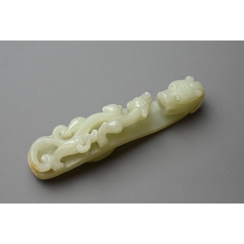 377 - A LARGE CHINESE PALE CELADON JADE BELT HOOK, QING DYNASTY, 18/19TH CENTURY. Carved in openwork on to... 