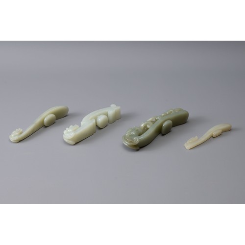 312 - FOUR CHINESE PALE CELADON DRAGON FORM BELT HOOKS, of various sizes, largest approx. 10 cm long (4)