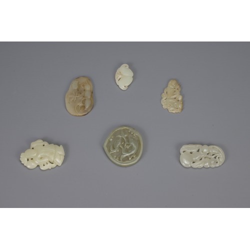 314 - SIX CHINESE CARVED PALE CELADON JADE PENDANTS, of different forms to include hanging double-gourds, ... 