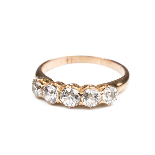 42 - A HIGH CARAT ROSE GOLD DIAMOND RING, MID 20TH CENTURY. With a row of five round cut diamonds. Unmark... 