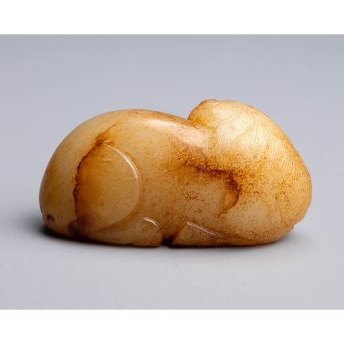 64 - A CHINESE YELLOW AND RUSSET JADE CARVING OF A RECUMBENT HORSE, MING DYNASTY (1368-1644). Carved with... 