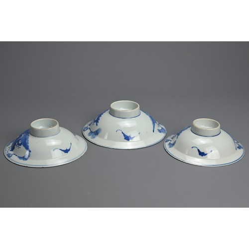 1 - THREE CHINESE BLUE AND WHITE BOWLS, 19TH CENTURY. Shallow rounded sides on a raised foot with everte... 