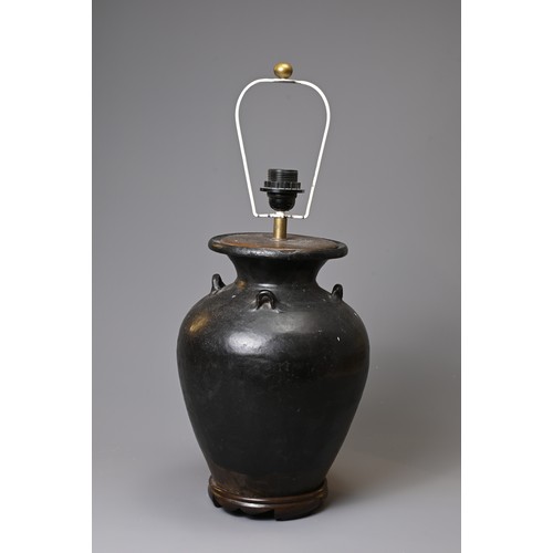 156 - A CHINESE BLACK GLAZED STONEWARE OVIFORM VASE ADAPTED AS A LAMP. With everted rim and lug handles, o... 