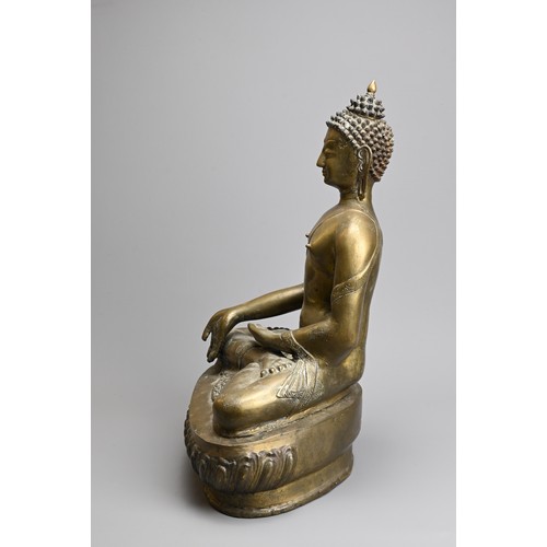 204 - A TIBETAN CAST BRONZE FIGURE OF SHAKYAMUNI, 20TH CENTURY. Seated on a lotus base dressed in robes de... 