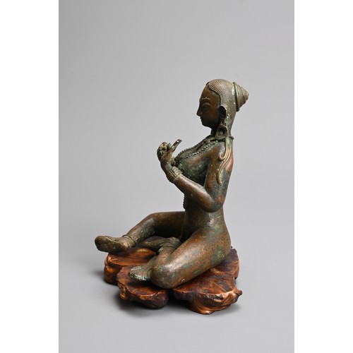 216 - A NEPALESE BRONZE FIGURE OF PARVATI, 20TH CENTURY. Together with a carved wooden base. 14cm tall.