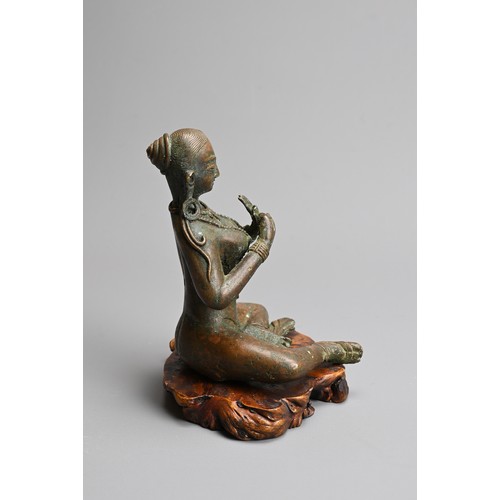 216 - A NEPALESE BRONZE FIGURE OF PARVATI, 20TH CENTURY. Together with a carved wooden base. 14cm tall.