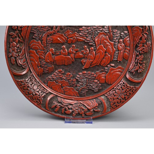 86 - A CHINESE CARVED CINNABAR LACQUER DISH, 19TH CENTURY. Carved in relief with scholars in landscape sc... 