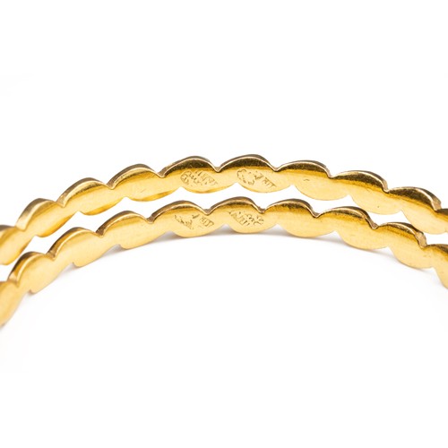 51 - A PAIR OF HIGH CARAT YELLOW GOLD HINGED TWISTED BRACELETS, MID 20TH CENTURY. Unmarked but testing as... 