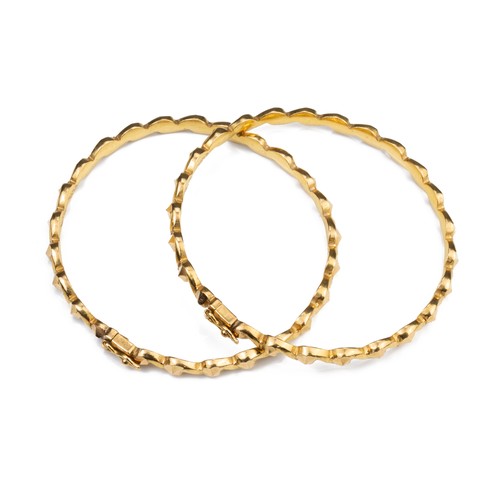 51 - A PAIR OF HIGH CARAT YELLOW GOLD HINGED TWISTED BRACELETS, MID 20TH CENTURY. Unmarked but testing as... 