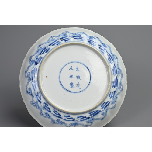 87 - A CHINESE BLUE AND WHITE PORCELAIN DISH, EARLY 18TH CENTURY. Of lobed form decorated with scholars a... 