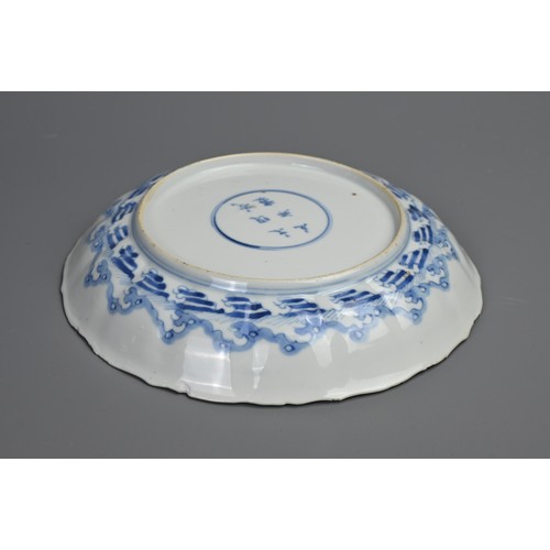 87 - A CHINESE BLUE AND WHITE PORCELAIN DISH, EARLY 18TH CENTURY. Of lobed form decorated with scholars a... 