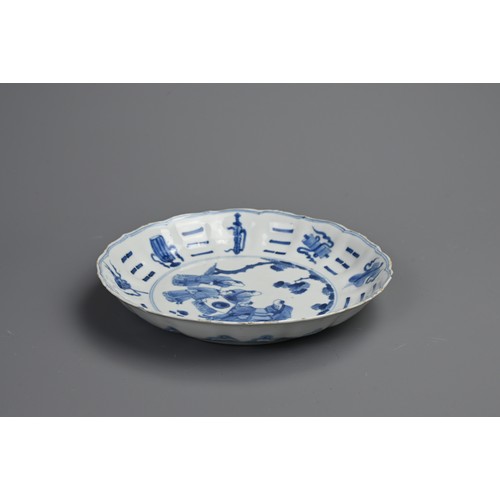 87 - A CHINESE BLUE AND WHITE PORCELAIN DISH, EARLY 18TH CENTURY. Of lobed form decorated with scholars a... 