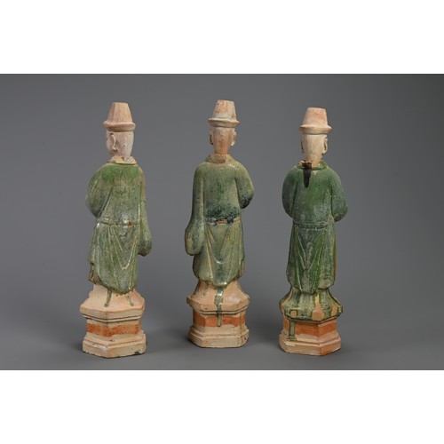 171 - THREE LARGE CHINESE SANCAI GLAZED POTTERY MODELS OF ATTENDANTS, MING DYNASTY (1368-1644). Standing d... 