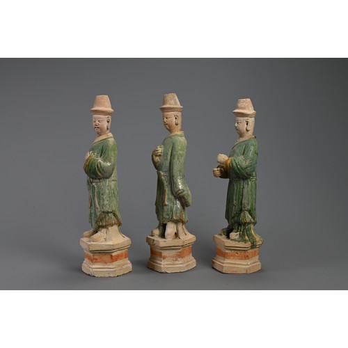 171 - THREE LARGE CHINESE SANCAI GLAZED POTTERY MODELS OF ATTENDANTS, MING DYNASTY (1368-1644). Standing d... 