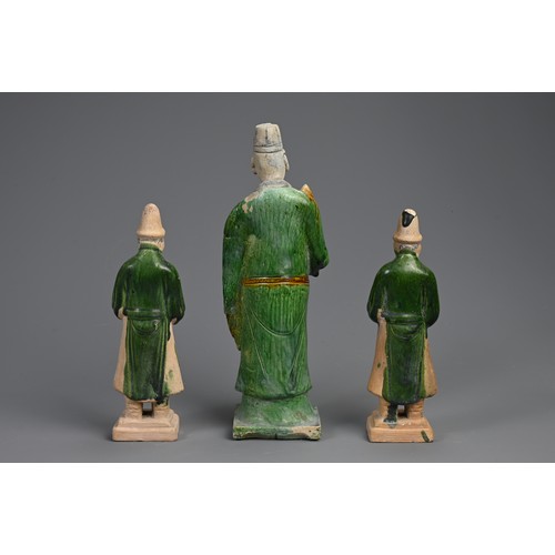 172 - THREE SANCAI AND GREEN GLAZED POTTERY MODELS OF ATTENDANTS, MING DYNASTY (1368-1644). Dressed in rob... 