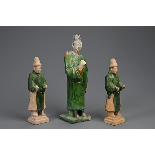 172 - THREE SANCAI AND GREEN GLAZED POTTERY MODELS OF ATTENDANTS, MING DYNASTY (1368-1644). Dressed in rob... 