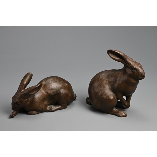 308 - A PAIR OF JAPANESE BRONZE OKIMONO OF HARES, USAGI, EARLY 20TH CENTURY. Naturalistically modelled in ... 