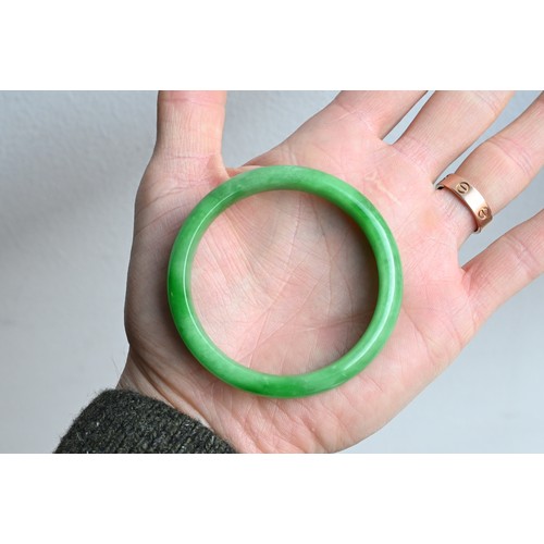 58 - A JADEITE CIRCULAR BANGLE. Of D shape. Total diameter 7cm, Inner diameter 5.7mm. Weight 41.7 grams