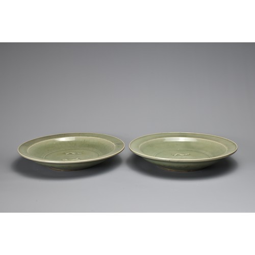 19 - TWO CHINESE LONGQUAN CELADON 'TWIN FISH' DISHES. Each thickly potted with shallow rounded sides and ... 