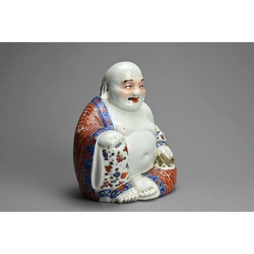 71 - A CHINESE FAMILLE ROSE PORCELAIN FIGURE OF BUDAI, 20TH CENTURY. The laughing Buddha seated dressed i... 