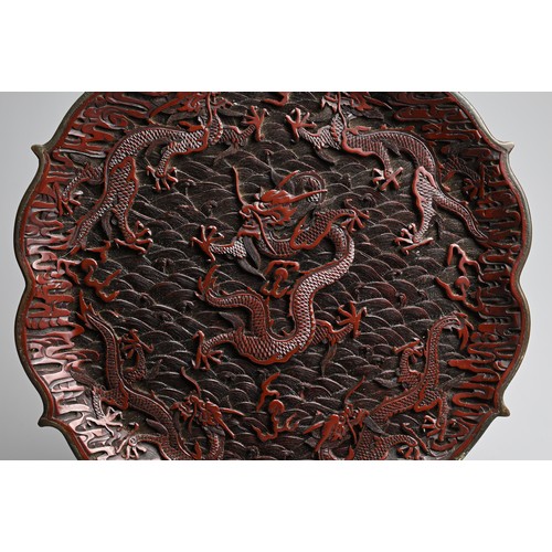 86 - A CHINESE RED LACQUER DRAGON DISH, 20TH CENTURY. With bracket lobed rim finely carved in relief with... 