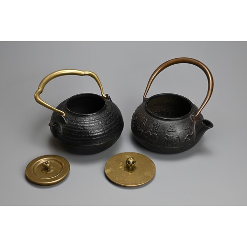 87 - TWO JAPANESE CAST IRON TEAPOTS WITH BRONZE HANDLES, 20TH CENTURY. One decorated in relief with the t... 