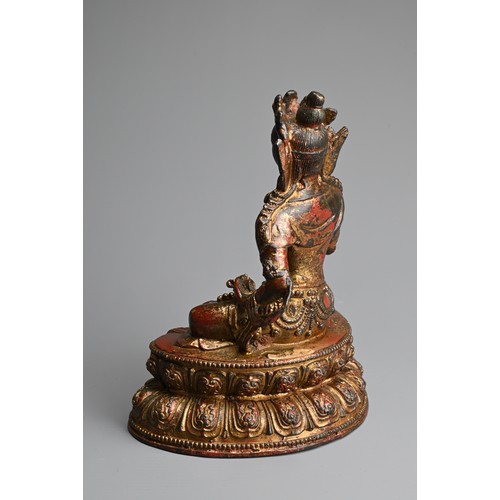 94 - A CHINESE RED LACQUERED AND GILT BRONZE FIGURE OF TARA. Seated on lotus base holding ritual items. 1... 