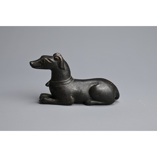 3 - A CHINESE BRONZE PAPERWEIGHT, QING DYNASTY. In the form of a recumbent dog, front facing wearing a c... 