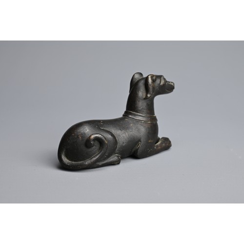 3 - A CHINESE BRONZE PAPERWEIGHT, QING DYNASTY. In the form of a recumbent dog, front facing wearing a c... 