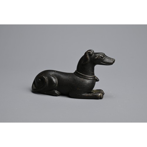 3 - A CHINESE BRONZE PAPERWEIGHT, QING DYNASTY. In the form of a recumbent dog, front facing wearing a c... 