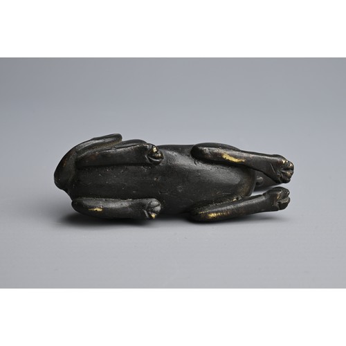 3 - A CHINESE BRONZE PAPERWEIGHT, QING DYNASTY. In the form of a recumbent dog, front facing wearing a c... 