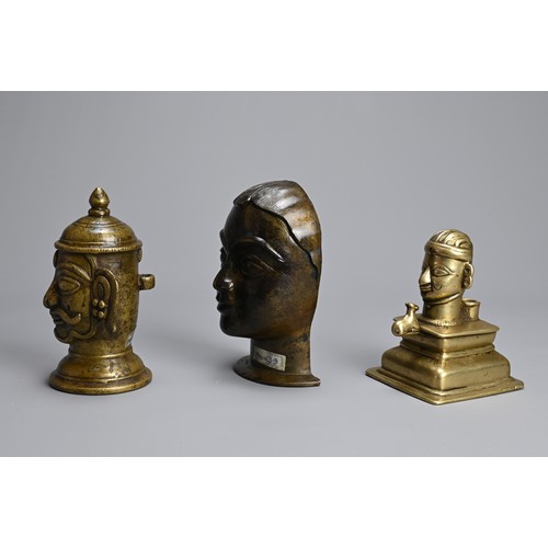 99 - THREE INDIAN BRASS / BRONZE HEADS OF SHIVA AND GAURI. The icons front facing on raised pedestals. 10... 