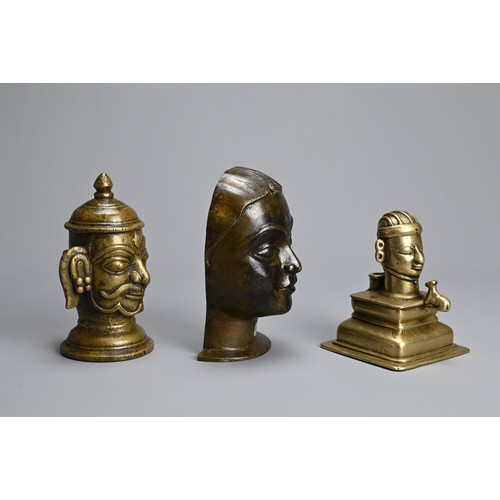 99 - THREE INDIAN BRASS / BRONZE HEADS OF SHIVA AND GAURI. The icons front facing on raised pedestals. 10... 