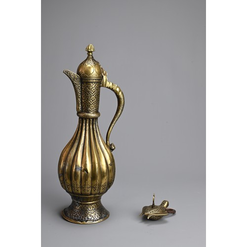 103 - AN ISLAMIC BRASS EWER AND LOCK. The ewer of lobed form  on splayed foot with hinged cover. Together ... 