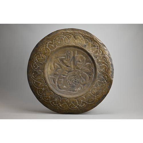 120 - A LARGE ISLAMIC BRONZE CIRCULAR PLAQUE. With central roundel with script surrounded by a band of scr... 