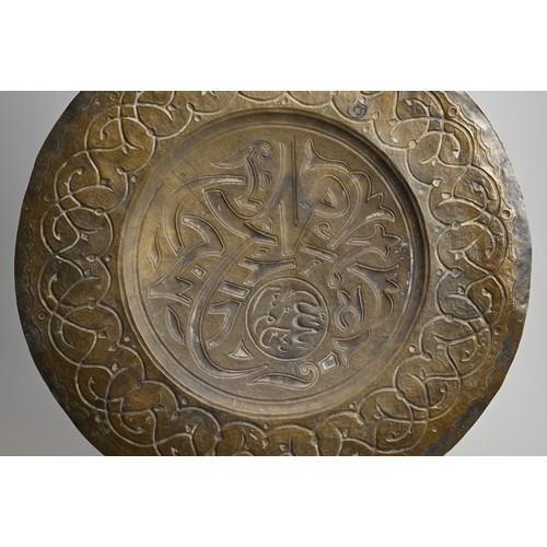 120 - A LARGE ISLAMIC BRONZE CIRCULAR PLAQUE. With central roundel with script surrounded by a band of scr... 