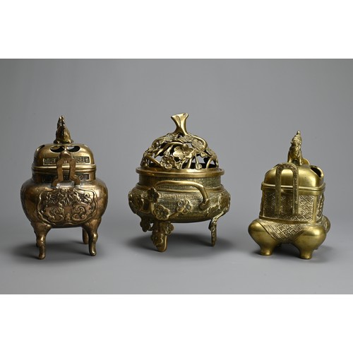 30 - THREE CHINESE POLISHED BRONZE INCENSE BURNERS WITH COVERS, 20TH CENTURY. Of various forms with pierc... 