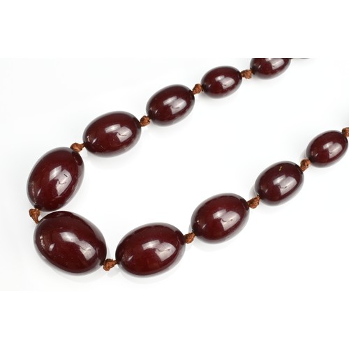 33 - A SINGLE STRAND CHERRY AMBER BEADED NECKLACE. With 36 graduating beads, strung and knotted (no clasp... 