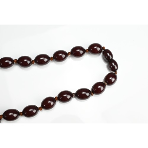 33 - A SINGLE STRAND CHERRY AMBER BEADED NECKLACE. With 36 graduating beads, strung and knotted (no clasp... 