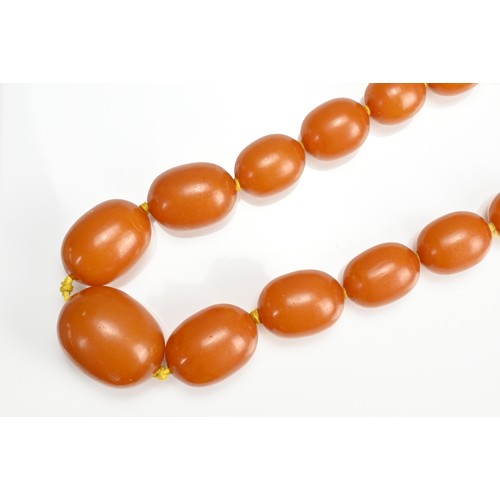 34 - A BUTTERSCOTCH AMBER SINGLE STRAND GRADUATED BEADED NECKLACE. With twenty-one graduating beads, stru... 